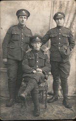 Three soldiers posing for photo, two are standing, one is sitting. England World War I Postcard Postcard Postcard