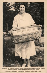 Madame D. Legros, Midwife of the Dionne Quinuptlets with her basket in which the five babies were placed after birth. Postcard
